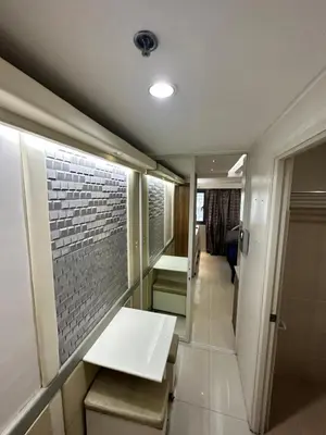 a bathroom with a bench and a brick wall at Grand Riviera Suits in Manila