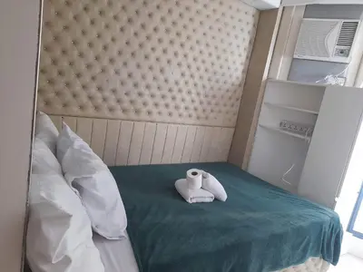a room with a bed with a white towel on it at Grand Riviera Suits in Manila