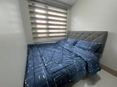 a bed with blue comforter and pillows in a bedroom at Shore 3 Residences, Tower 1 Mall of Asia Complex, Pasay City, Metro Mania in Manila