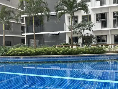 a swimming pool in front of a building with palm trees at Shore 3 Residences, Tower 1 Mall of Asia Complex, Pasay City, Metro Mania in Manila