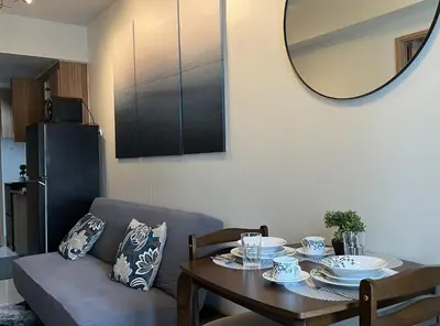 a living room with a table and a couch and a mirror at Shore 3 Residences, Tower 1 Mall of Asia Complex, Pasay City, Metro Mania in Manila