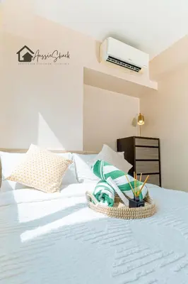 a white bed with a basket of towels on it at Aussie Shack - 2BR Modern Condo with Skyline View in Manila