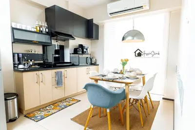 a kitchen with a dining room table and chairs at Aussie Shack - 2BR Modern Condo with Skyline View in Manila