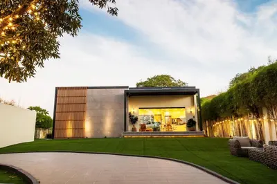 a modern house with a green lawn at Orchard Tiny Home - Golf Course Pet Friendly Lot in Baluctot