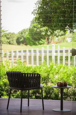 a bench and a table in front of a fence at Orchard Tiny Home - Golf Course Pet Friendly Lot in Baluctot