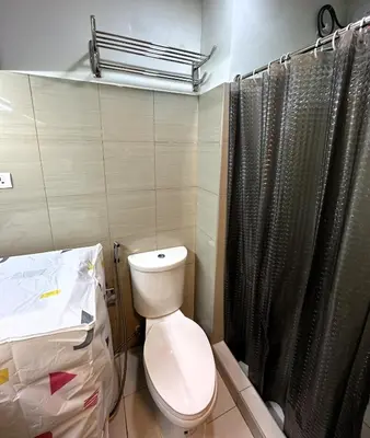 a bathroom with a toilet and a shower at Victoria’s Place in Manila