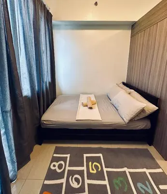 a small room with a bed with two shoes on it at Victoria’s Place in Manila