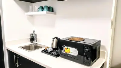 a microwave sitting on a kitchen counter next to a sink at ROARI Portovita Towers Scandinavian Studio Unit in Manila