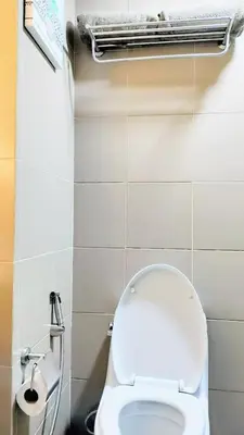 a bathroom with a white toilet and a radiator at ROARI Portovita Towers Scandinavian Studio Unit in Manila