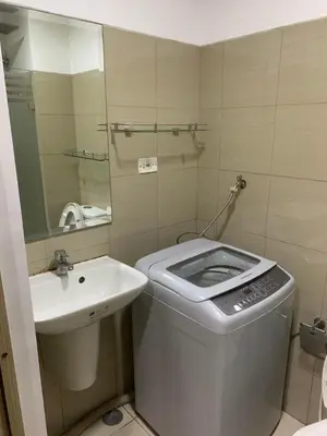 a bathroom with a trash can next to a sink at EZStays Shore Residences in Manila
