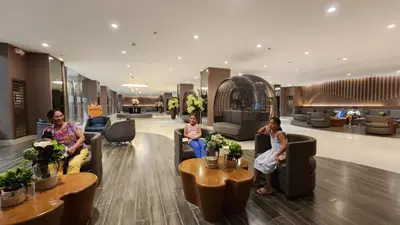 a group of people sitting on couches in a lobby at EZStays Shore Residences in Manila