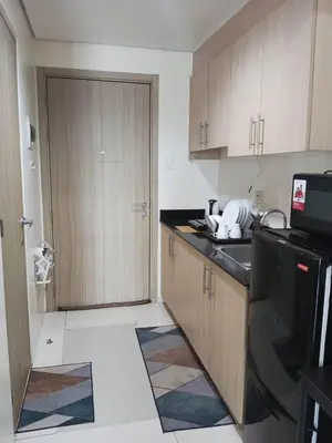 a kitchen with a sink and a door to a room at Breeze Residences - 1BR Unit with Balcony -Top Floor in Manila