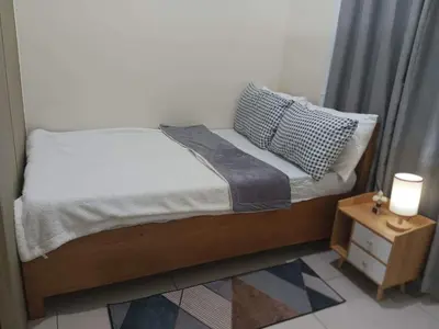 a small bed in a bedroom with a night stand at Breeze Residences - 1BR Unit with Balcony -Top Floor in Manila