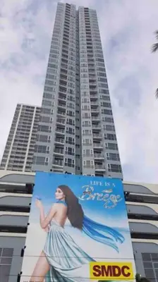 a large building with a picture of a woman on it at Breeze Residences - 1BR Unit with Balcony -Top Floor in Manila