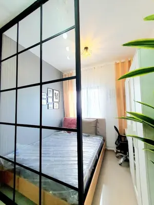a bedroom with a bed and a glass wall at Green 2 Residences Scandi-Industrial Hotel Type Interior in Dasmariñas