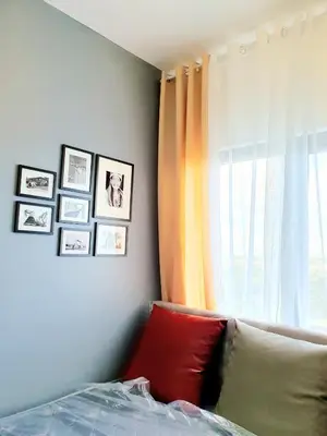 a bedroom with a bed and a window with pictures at Green 2 Residences Scandi-Industrial Hotel Type Interior in Dasmariñas