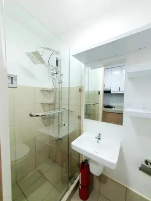 a white bathroom with a sink and a shower at Green 2 Residences Scandi-Industrial Hotel Type Interior in Dasmariñas