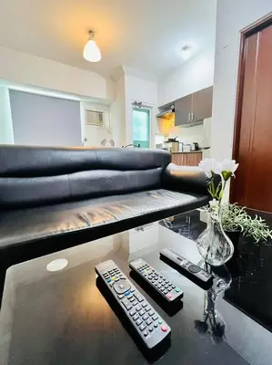 a living room with a couch and two remote controls at Sweet Home with WiFi and Netflix in Manila
