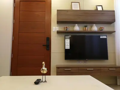 a living room with a television and a table with a remote control at Adria Residences - Ruby Garden - 2 Bedroom for 4 person in Manila
