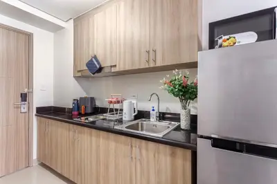 a kitchen with a sink and a refrigerator at Shore 2 Apartment with Balcony in Manila
