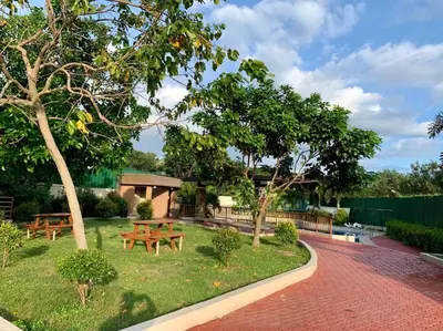 a garden with two picnic tables and trees at Cozy Place Anuva Residences in Manila