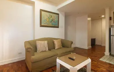 a living room with a couch and a coffee table at Sunette Tower Makati in Manila