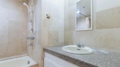 a bathroom with a sink and a shower and a tub at Sunette Tower Makati in Manila