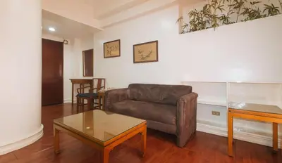 a living room with a couch and a table at Sunette Tower Makati in Manila