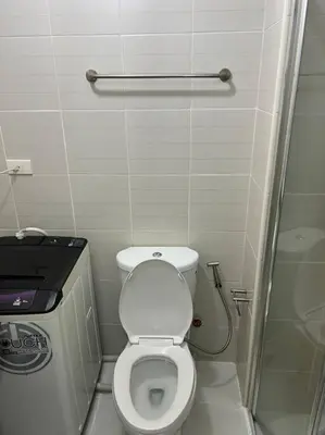 a small bathroom with a toilet and a shower at JAZZ Residences - 1 Bedroom with Balcony - Cable, Wifi & Netflix in Manila