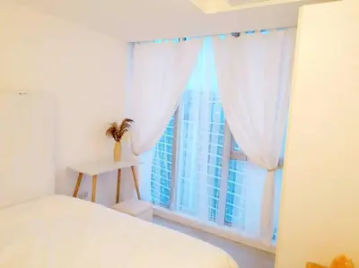 a bedroom with a white bed and a large window at Azure SKYVIEW PENTHOUSE minimalist unit in Manila