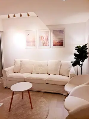 a living room with a white couch and a table at Azure SKYVIEW PENTHOUSE minimalist unit in Manila