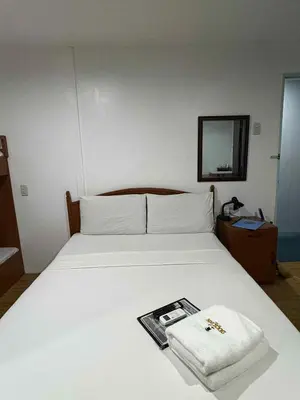 a white bed with a towel on top of it at DUCK INN AND RESTAURANT in Manila