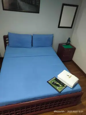 a bed with blue sheets and a book on it at DUCK INN AND RESTAURANT in Manila