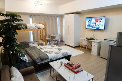 a living room with a bunk bed and a couch at A2J Luxury Venice Studio Suite Near BGC Malls in Manila