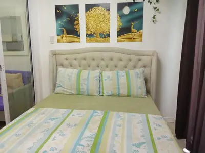 a bed in a bedroom with two pictures on the wall at Azure Urban Resort with WIFI and Netflix in Manila