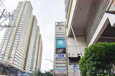 a group of tall buildings in a city with signs at Birchtower by Jeizel Manila City in Manila