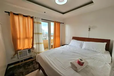 a bedroom with a large bed with a window at Birchtower by Jeizel Manila City in Manila