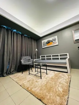 a bedroom with a bed and a chair and a rug at C-UY Realtae in Manila