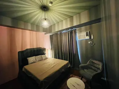 a small bedroom with a bed and a chair at C-UY Realtae in Manila