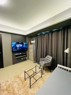 a bedroom with a bed and a tv and a chair at C-UY Realtae in Manila