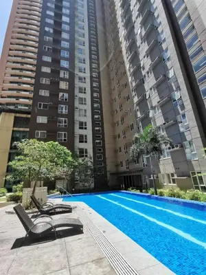 a swimming pool in front of some tall buildings at C-UY Realtae in Manila