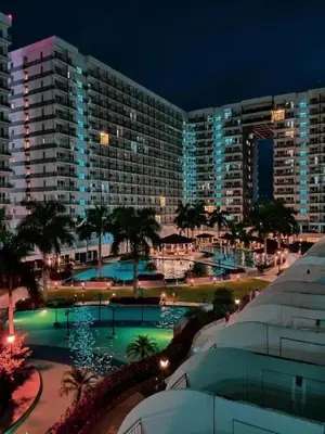 a view of a hotel with a pool at night at Shell Residences C15 Shortwalk Sm Mall Of Asia/Airport in Manila
