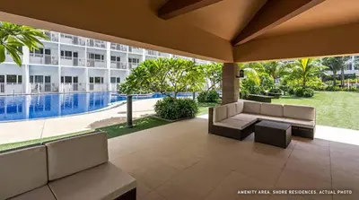 a patio with couches and a pool in front of a building at Shore Residence D10 Near Mall Of Asia- Airport in Manila