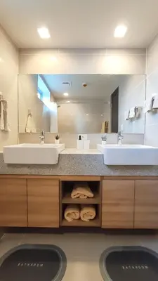 a bathroom with two sinks and a large mirror at Uptown Parksuites BGC 2 bedroom 2 bath in Manila