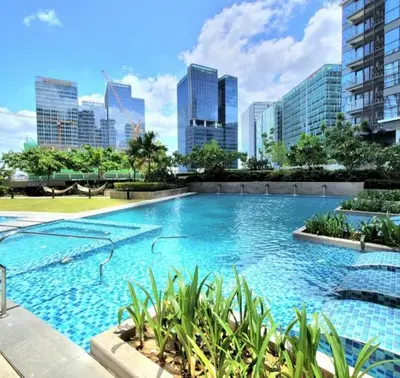 a large swimming pool with a city skyline in the background at Uptown Parksuites BGC 2 bedroom 2 bath in Manila