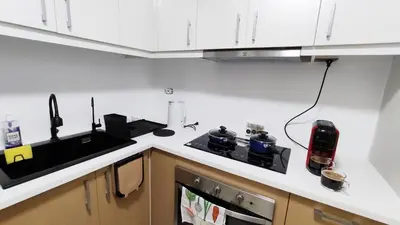 a kitchen with white cabinets and a counter top at Uptown Parksuites BGC 2 bedroom 2 bath in Manila