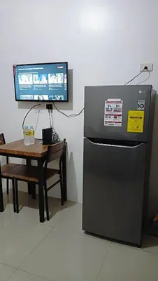 a small refrigerator next to a table with a tv at Shore Residence D12 Near Airport- SM Mall Of Asia in Manila
