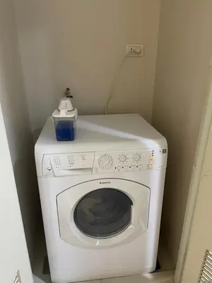 a white washing machine with a blue box on top of it at One Uptown Residence BGC in Manila