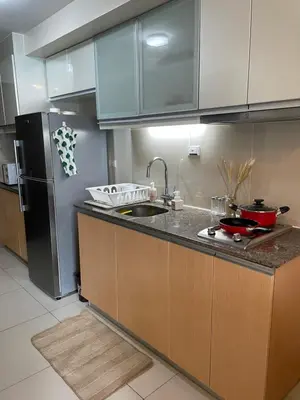 a kitchen with a sink and a refrigerator at One Uptown Residence BGC in Manila