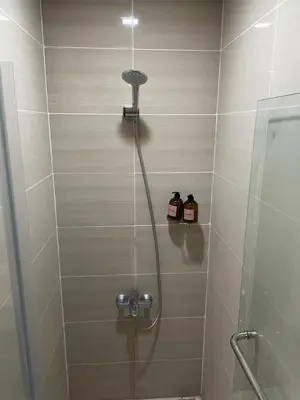 a shower in a bathroom with a glass door at One Uptown Residence BGC in Manila